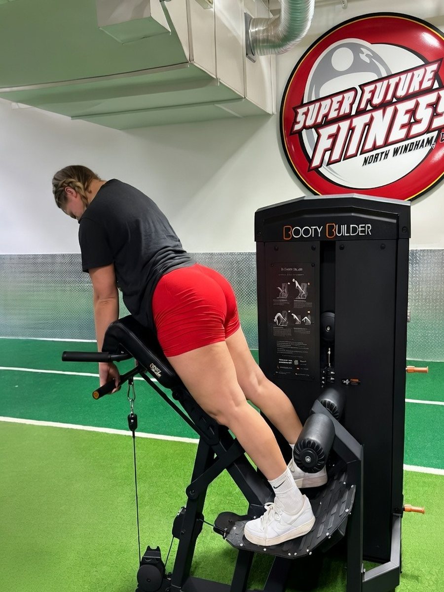 Member training on the Booty Builder Selectorized Back Extension on the turf at Super Future Fitness