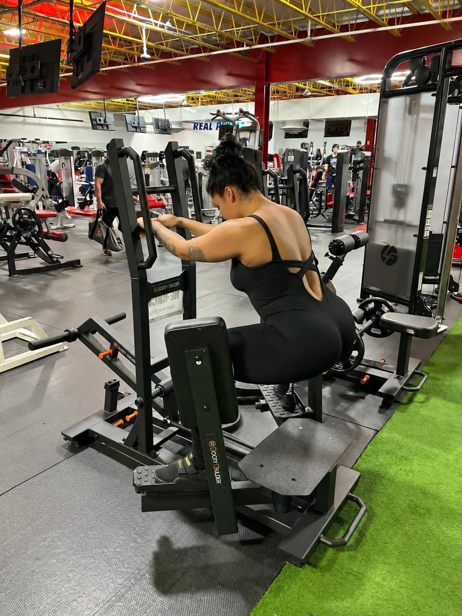 Member training on a plate-loaded Booty Builder machine at Super Future Fitness